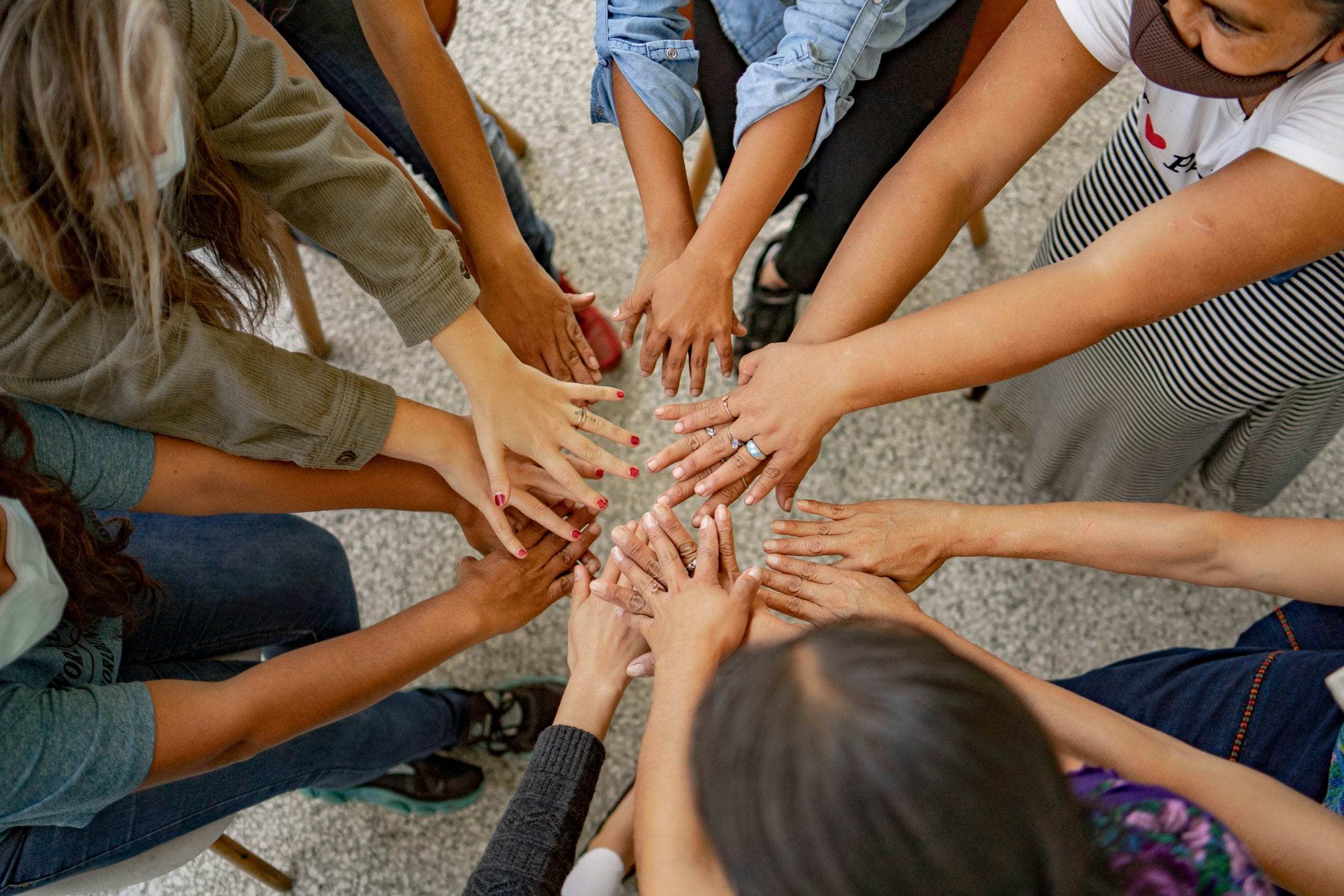 Group joining hands in unity.